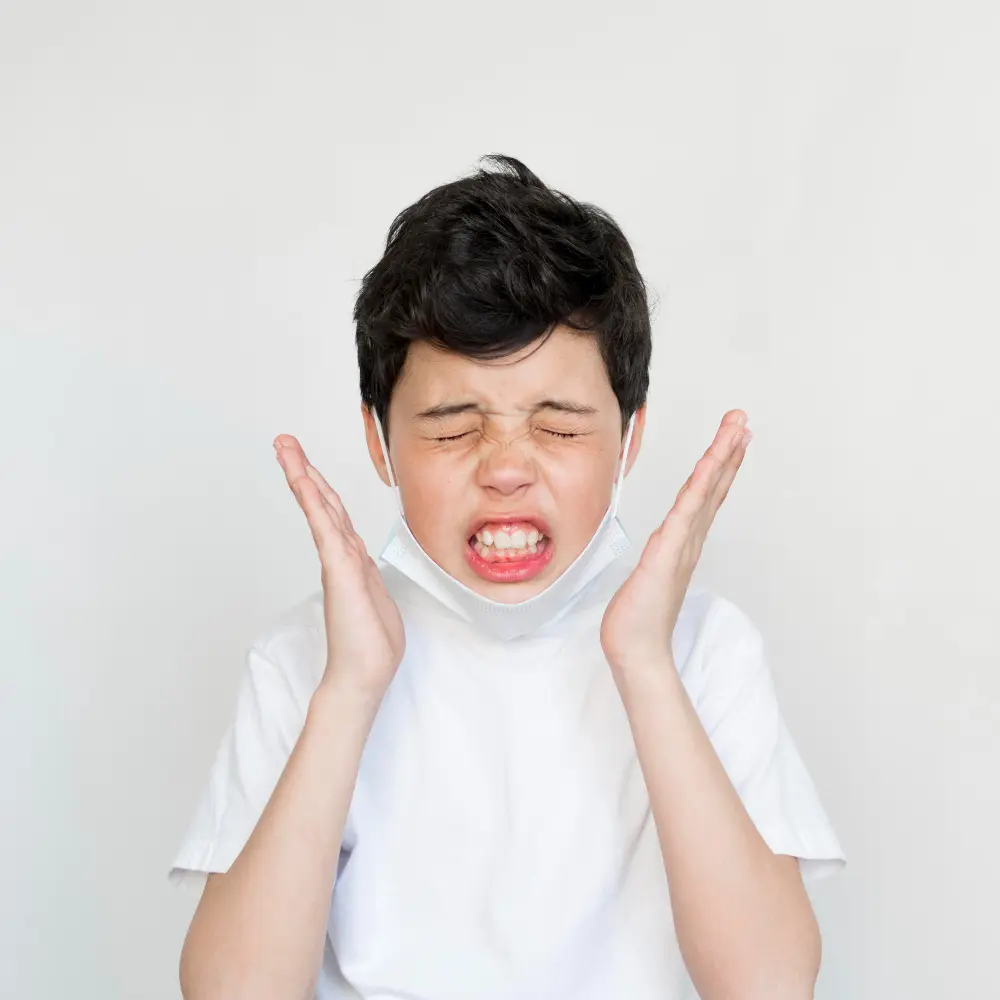 a boy with mouth open and mouth open with hands on his face