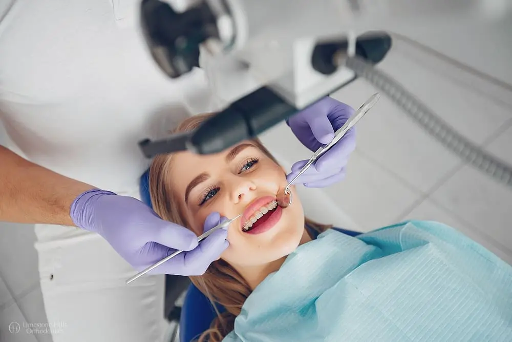 Beautiful girl sitting in the dentist's office, smiling while receiving dental care using advanced orthodontic technology.