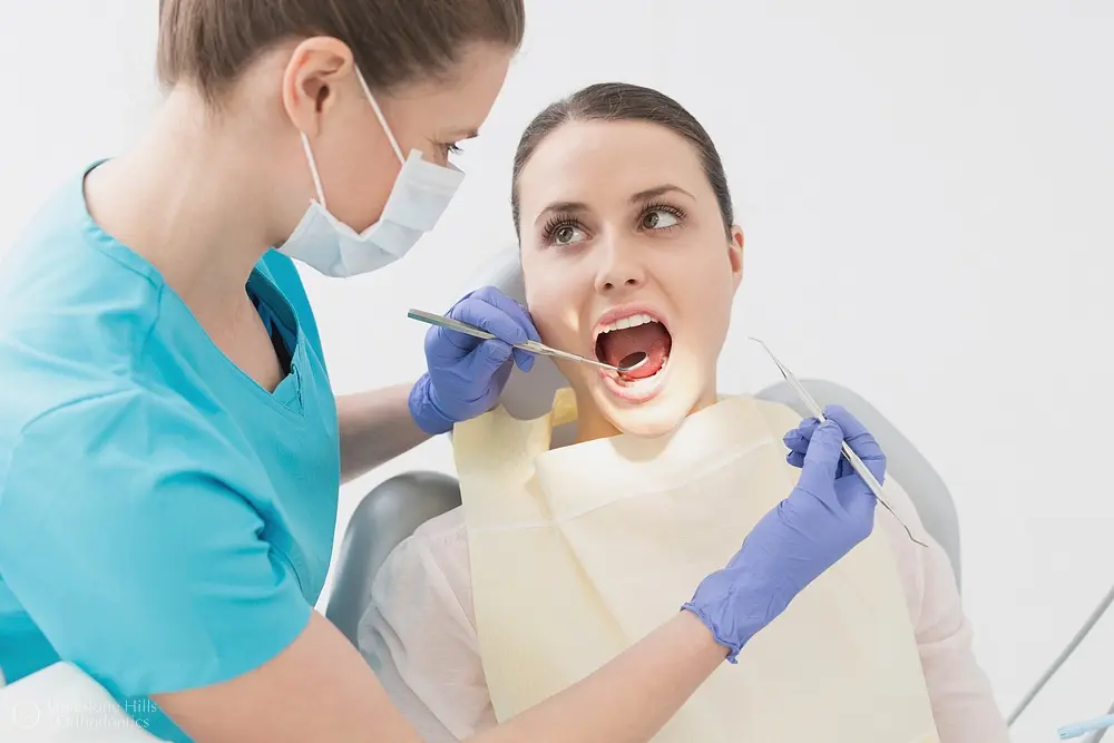 In Austin, TX, at Limestone Hills Orthodontics, a dentist examines a patient's mouth, discussing functional appliances & myofunctional therapy.