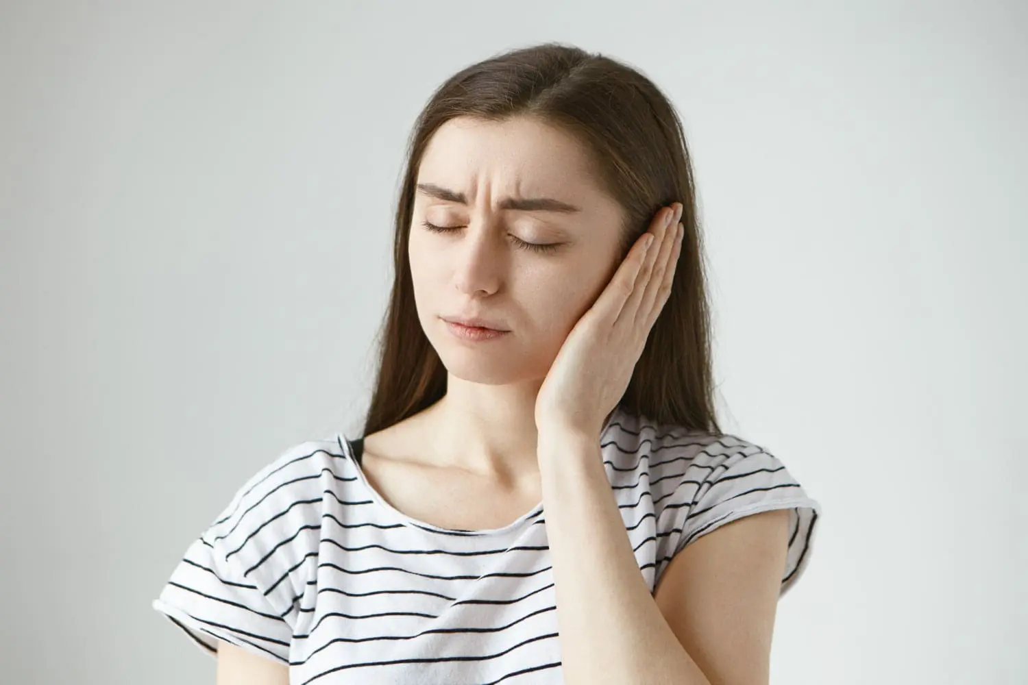 A woman with long brown hair represents when a TMJ splint is indicated at Limestone Hills Orthodontics in Austin, TX.