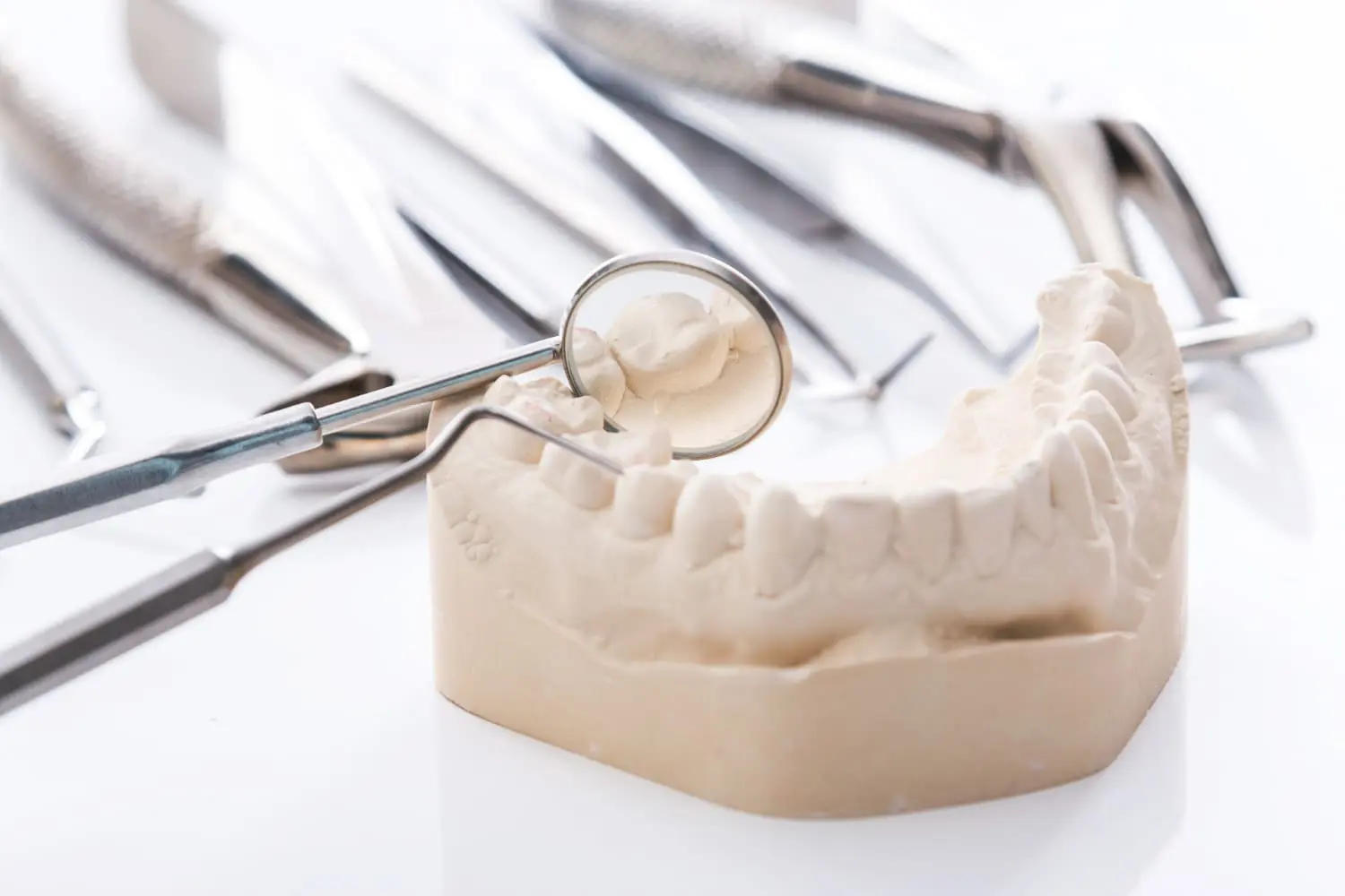 A dental mold with tools and a mirror highlights how Limestone Hills Orthodontics in Austin, TX aids TMJ mouth guard care.